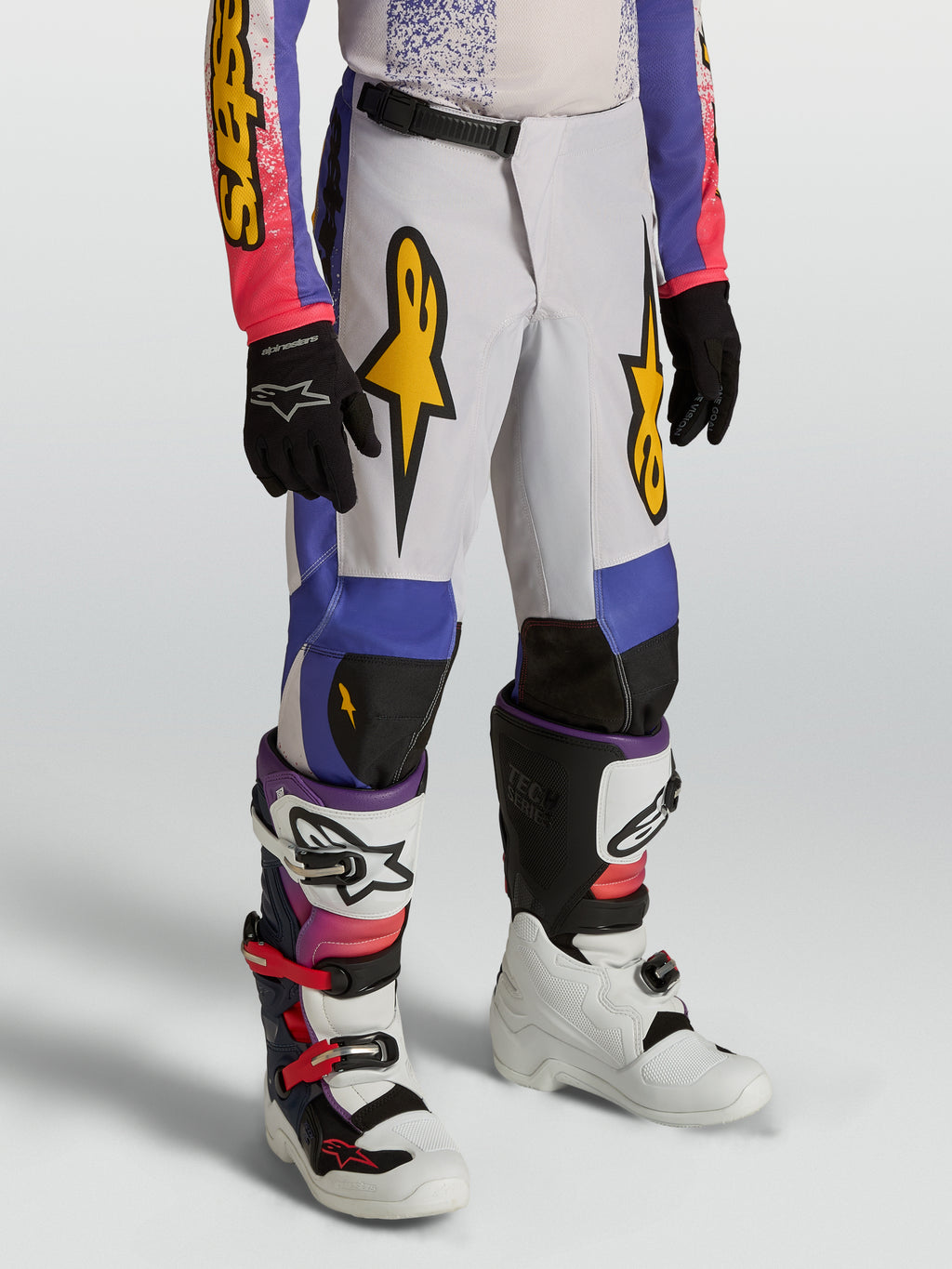 Alpinestars Pantalones Fluid Drag Juvenil, pantalones de motocross en color gris, azul y morado con gráficos dorados, diseño ergonómico precurvado para conducción off-road, ajuste deportivo ligero