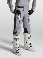Pantalones Alpinestars Fluid Amber Juvenil, pantalones de motocross para niños, gris arena y blanco, gráficos de estrellas, paneles reforzados y ajuste deportivo para off-road