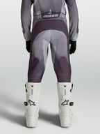 Pantalones de motocross Alpinestars Fluid Amber Juvenil, gris y arena, con refuerzo en el asiento y paneles elásticos.