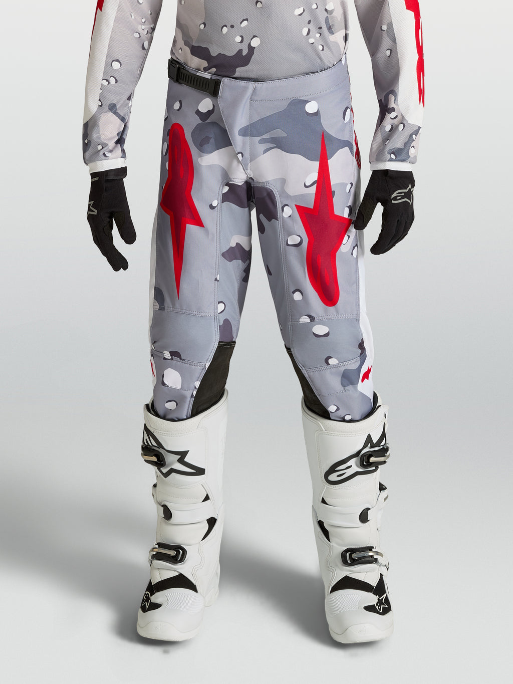 Pantalones Alpinestars Fluid Lone Juvenil, equipo de motocross en gris camo y rojo fuego, construcción de polifabric resistente con ajuste ergonómico para pilotaje off-road