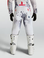 Alpinestars Fluid Lone Juvenil, pantalones de motocross grises y blancos con camuflaje y detalles rojos, vista trasera