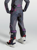 Pantalones Alpinestars Fluid Lone juveniles, de motocross, gris camuflaje y morados, vista trasera en modelo.