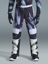 Alpinestars 2026 Youth Fluid Lahnd Pants, pantalones de motocross para jóvenes, Iron Camo con detalles blancos, usados con botas y guantes de off-road en blanco y negro, diseño duradero para jóvenes pilotos