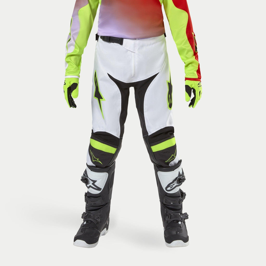 Alpinestars Youth 2024 Racer Lucent Pants, Motocross Pants, White with Neon Yellow and Black accents, worn with coordinating neon gloves and black boots, featuring ergonomic pre-curved legs and Alpinestars logos, high-performance gear for off-road racing
