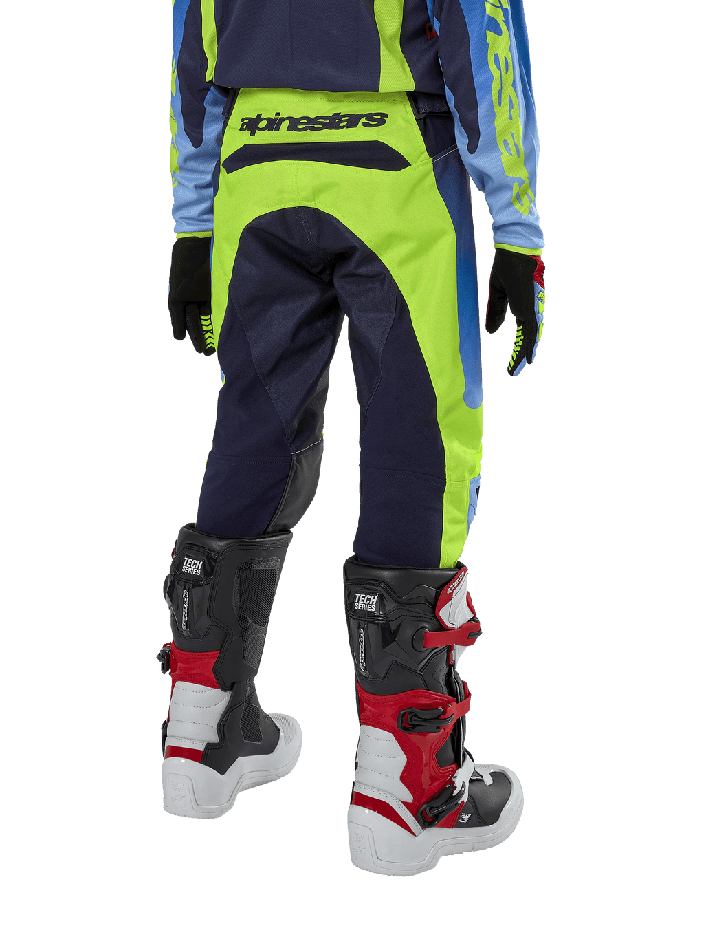 Pantalones Alpinestars Youth 2024 Racer Hoen, pantalones de motocross, amarillo flúor y azul noche, vista trasera con marca Alpinestars destacada en la cintura, usados con botas Tech Series negras y rojas y jersey a juego, diseño deportivo duradero para conducción off-road juvenil