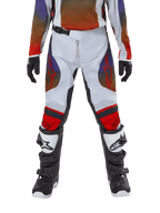 Alpinestars Youth 2024 Racer Hoen Pants, pantalones de motocross juveniles, gris claro, naranja vibrante y negro, usados con jersey a juego y botas de motocross blancas y negras, con logotipos rojos de Alpinestars en los muslos y las rodillas, diseño deportivo para carreras fuera de carretera