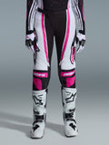 Alpinestars 2026 Stella Techstar Nomur para mujer, pantalones de motocross, negro, blanco y fucsia, usados con jersey de carreras, guantes a juego y botas de motocross blancas, con gráficos rosas llamativos y logotipos astars en las rodillas, diseñados para competición off-road de alto nivel.
