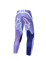Alpinestars 2026 Stella Fluid Apex Pants, pantalones de motocross para mujer, violeta y blanco, vista trasera con grandes logos blancos de Alpinestars en el asiento, paneles azul oscuro y agarres negros en el interior de la rodilla, diseño de ajuste deportivo para conducción off-road