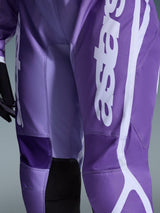 Alpinestars Stella Fluid Apex Pants 2026, pantalones de motocross para mujer, violeta y blanco, primer plano con el logotipo en blanco sobre tejido morado, paneles interiores de las rodillas reforzados en negro, construcción de polifabric duradera para conducción off-road