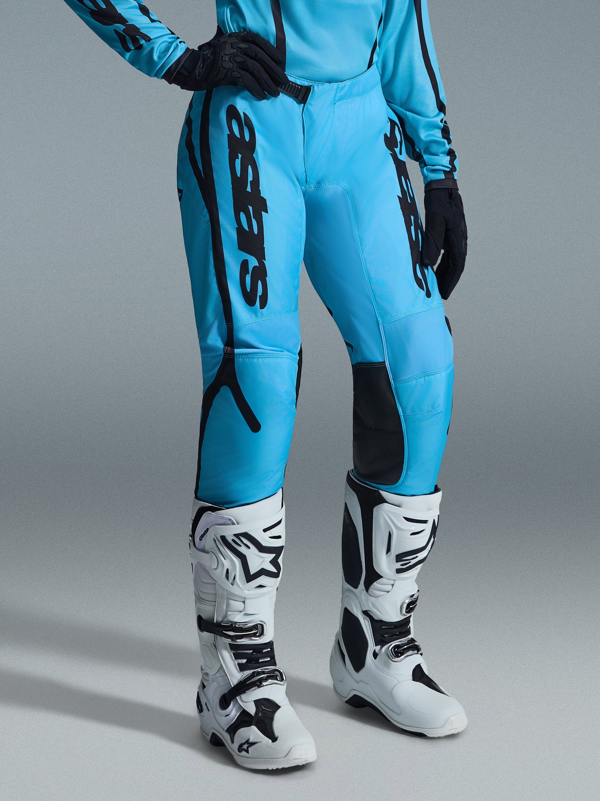 Alpinestars 2026 Stella Fluid Apex Pants para mujer, pantalones de motocross, azul brillante con logotipos en negro, usados con jersey a juego, guantes negros y botas de motocross blancas y negras, diseño ergonómico para un alto rendimiento