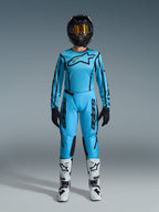Alpinestars 2026 Stella Fluid Apex Gear Set, jersey y pantalones de motocross para mujer, azul y negro, con un gran logo de estrella en el pecho, usado con casco negro, gafas tintadas y botas blancas con detalles negros, equipo completo para carreras off-road