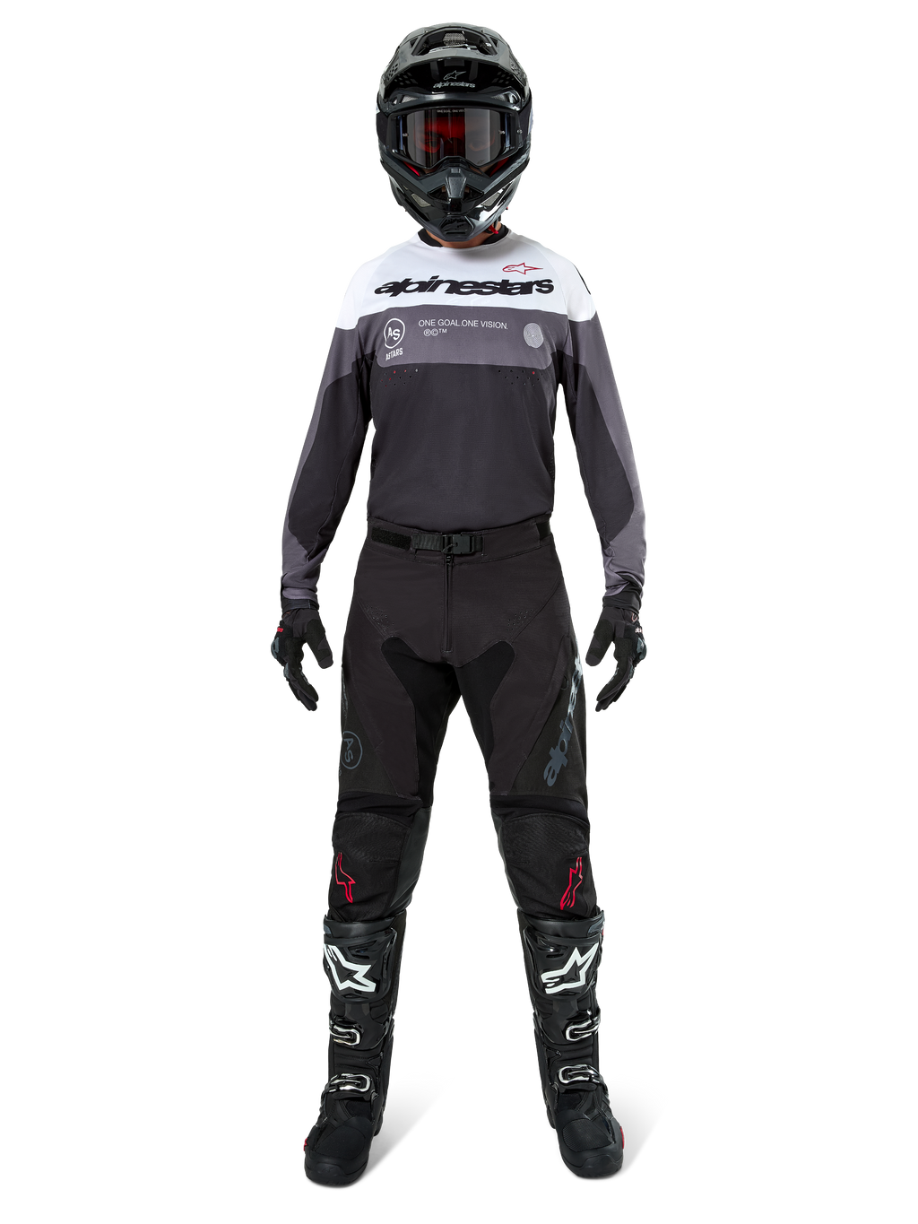 Piloto de motocross con equipamiento completo de competición, Jersey Pro-Dura en color Black Magnet White con la parte superior del pecho blanca y detalles en gris, combinado con pantalones negros, casco negro con gafas oscuras, botas blancas y negras y guantes negros, conjunto coordinado para enduro y carreras off-road.