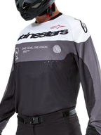 Alpinestars Pro-Dura Jersey, jersey de motocross y enduro, negro, gris magneto y blanco, ropa técnica off-road con perforaciones cortadas con láser y construcción de tejido de poliéster transpirable.