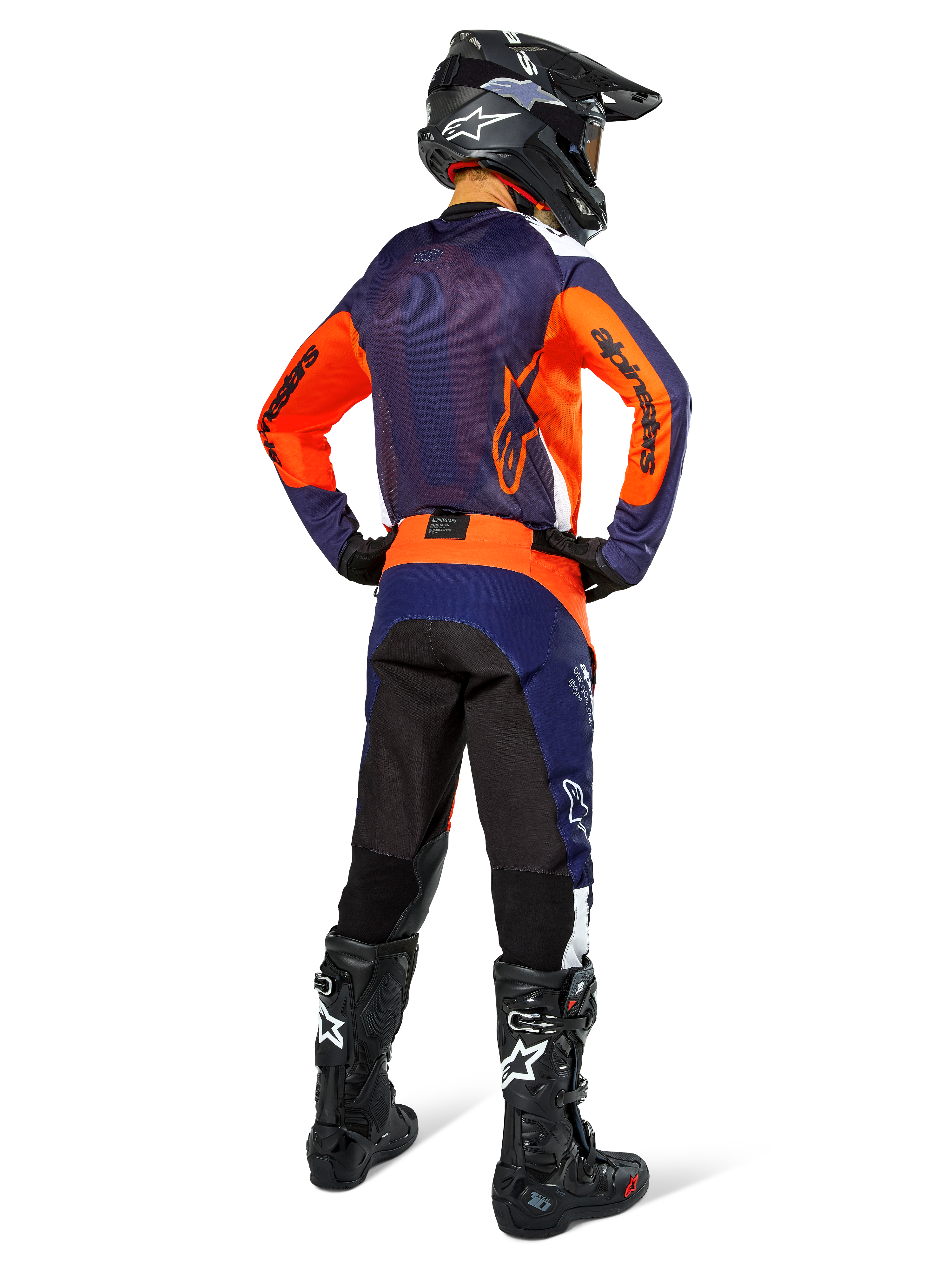 Motocross rider from the back wearing Alpinestars Pro-Dura Jersey, Navy Hot Orange and White, matching navy and orange pants, black helmet and black boots, featuring breathable mesh back panel and elongated rear, coordinated gear for enduro racing