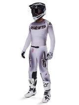 Motocross rider wearing the Alpinestars 2025 Supertech Maker Jersey in Silver and Black, matching silver and black pants, black and white helmet with black goggles, white and black boots, and coordinating gloves, professional gradient design for off-road racing