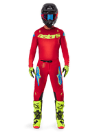 Motocross rider wearing complete Alpinestars 2025 Supertech Maker Gear Set, Bright Red jersey with yellow fluo 'astars' branding, matching red pants with blue accents, black helmet with blue goggles, bright yellow fluo boots and gloves, coordinated outfit for off-road racing