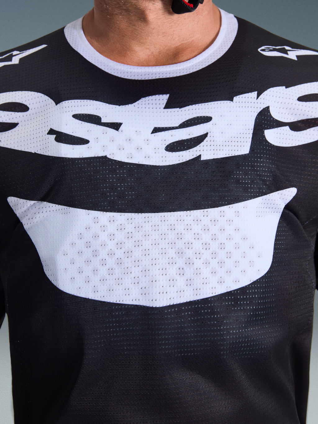 Alpinestars Racer Air Riway Jersey 2026, jersey de motocross, negro y blanco, primer plano del pecho con gran gráfico blanco y construcción de malla transpirable, cuello blanco y logotipos en los hombros