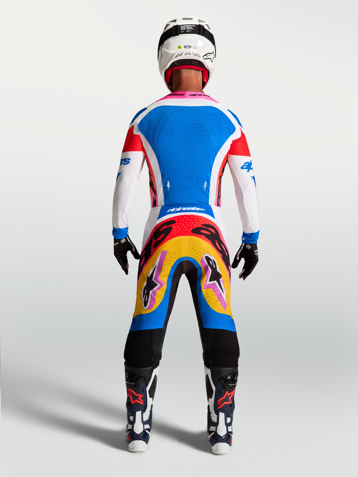 Alpinestars Supertech Dyna, jersey y conjunto de motocross para hombre, azul y blanco con detalles rosa, vista trasera en modelo.
