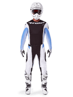 Piloto de motocross con la equipación completa Alpinestars 2025 Techstar Melt, jersey negro con mangas en degradado azul claro, pantalones blancos con detalles en negro y azul, casco blanco con gafas negras, botas y guantes blancos y negros, conjunto de equipación de motocross coordinado para carreras todoterreno