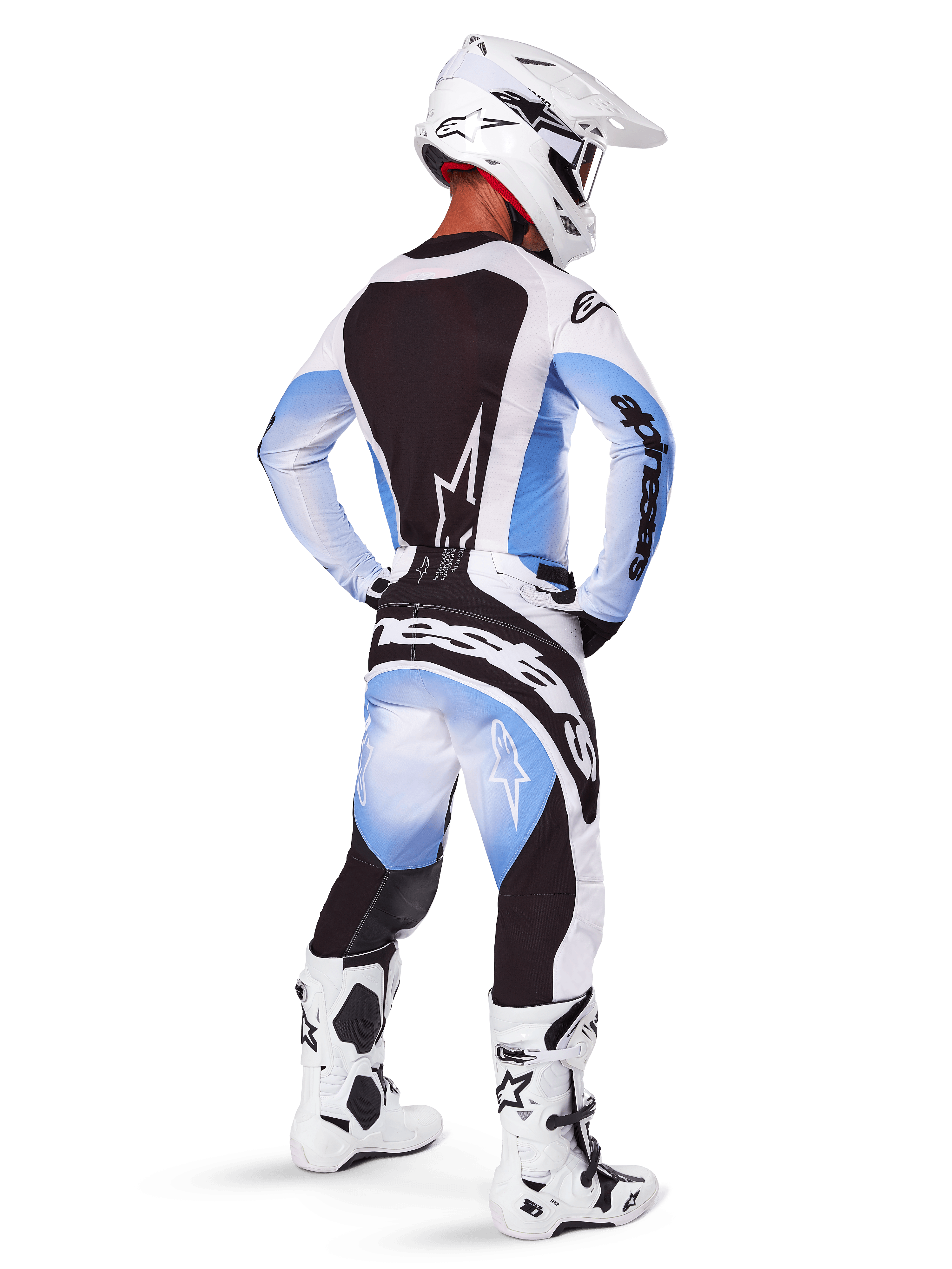 Piloto de motocross con equipamiento completo de carreras, conjunto de equipo Techstar Melt 2025, jersey blanco y azul claro con panel trasero negro, pantalones a juego con degradado azul y detalles negros, casco blanco, botas blancas y negras, conjunto coordinado para carreras todoterreno