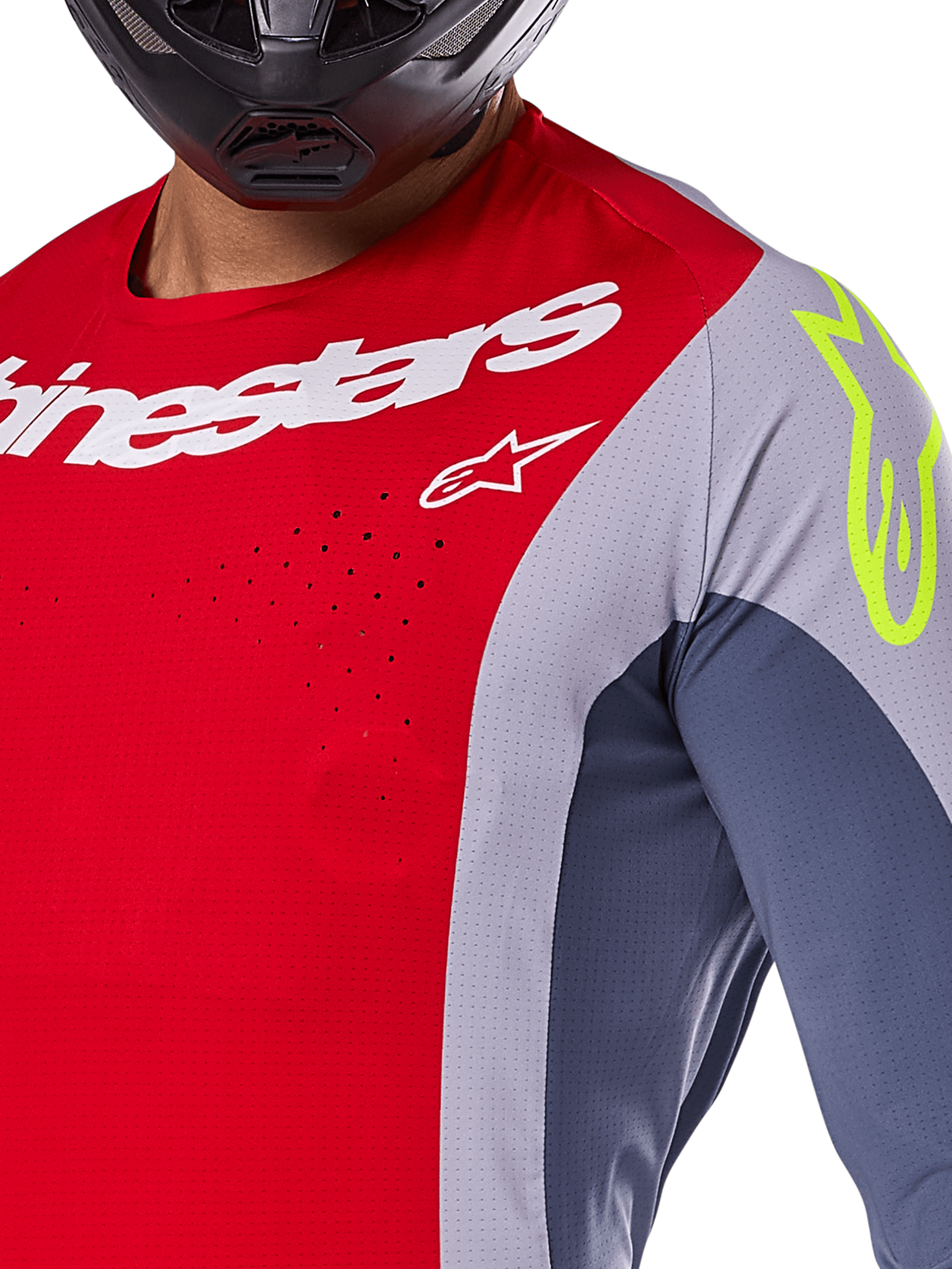 Alpinestars Techstar Melt Jersey 2025, jersey de motocross, rojo brillante y gris con paneles azul oscuro, con la marca Alpinestars en blanco y un logo amarillo neón en el hombro, primer plano que muestra las perforaciones de ventilación cortadas con láser y un casco negro.