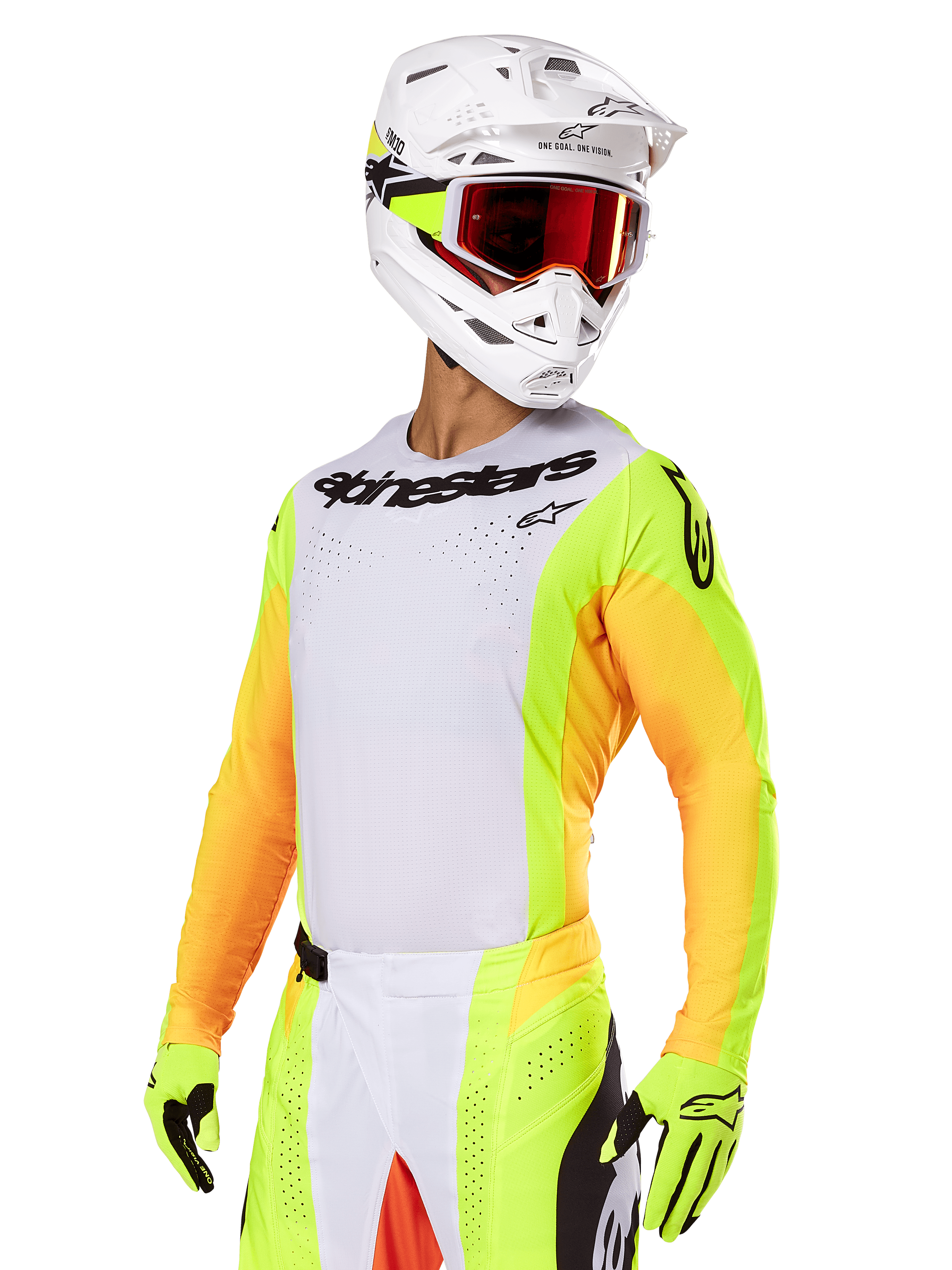 Piloto de motocross con el conjunto Alpinestars Techstar Melt 2025, jersey blanco con mangas amarillas y naranjas vibrantes, logotipo de Alpinestars negro en el pecho, guantes amarillo neón a juego, casco blanco con gafas de lente roja, kit profesional de carreras todoterreno