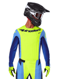 Alpinestars 2025 Techstar Melt Jersey, camiseta de motocross, amarillo flúor y azul, con ventilación cortada por láser y ajuste atlético de competición, usada por un piloto con casco negro y guantes amarillo flúor