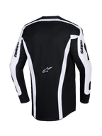 Alpinestars 2026 Racer Riway Jersey, jersey de motocross, blanco y negro, vista trasera que muestra el chasis negro con franjas verticales blancas y paneles en las mangas, logo Astars en el centro de la espalda, texto 'astars' en las mangas, corte trasero extendido para mayor cobertura en conducción off-road