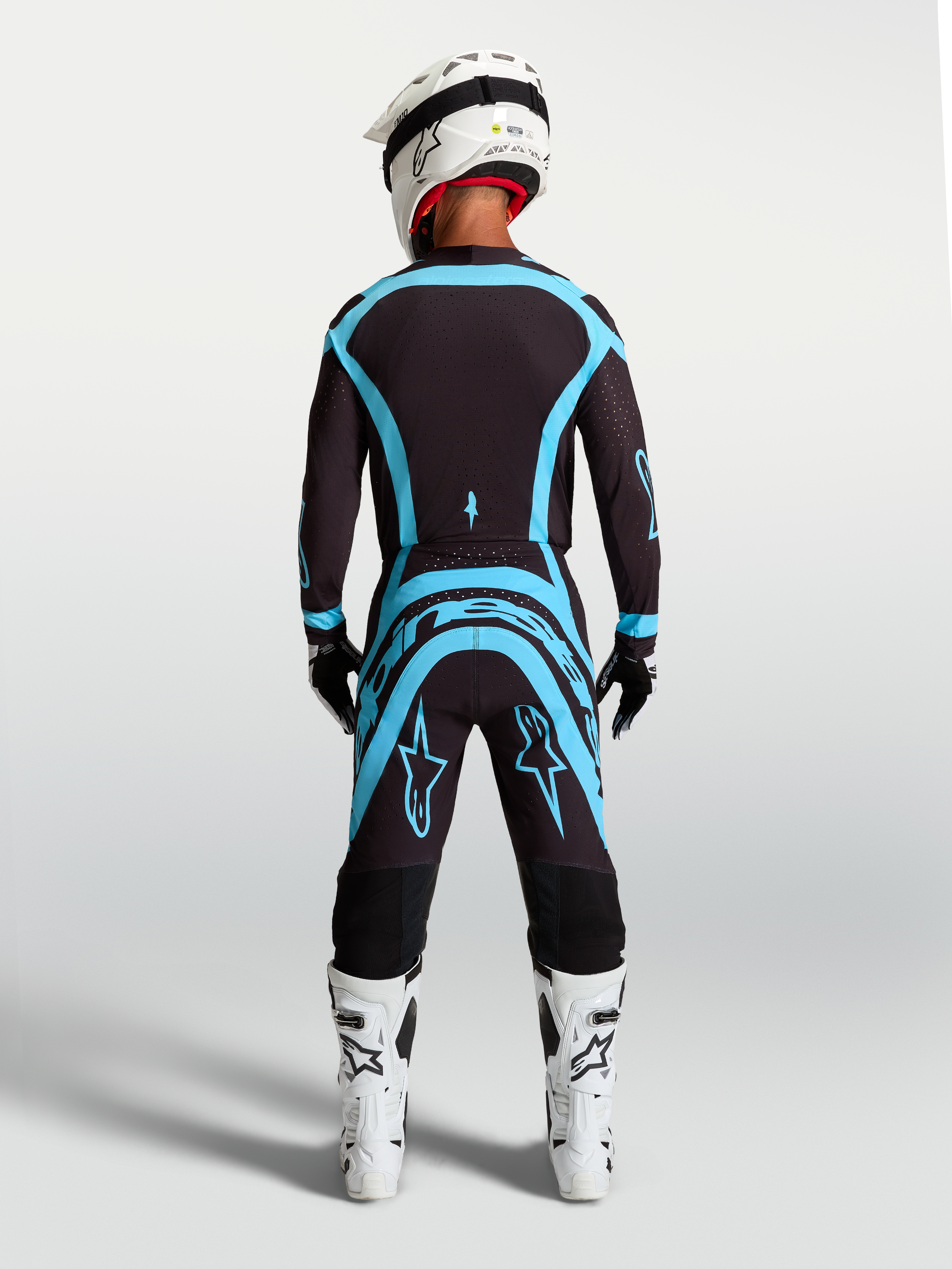 Alpinestars Supertech Vesta, conjunto de motocross, negro y turquesa, vista trasera de jersey y pantalones, ajuste atlético.