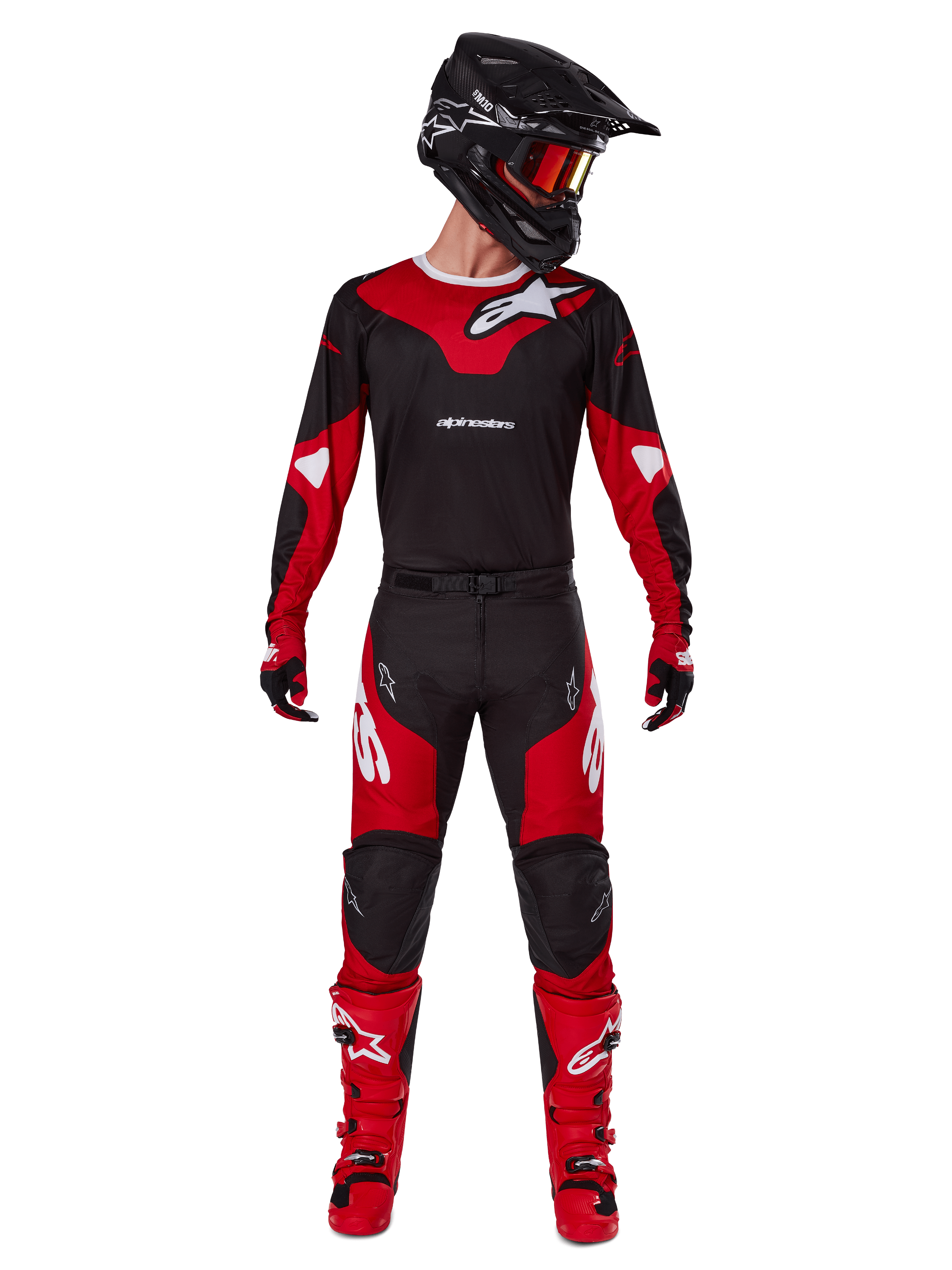 Piloto de motocross con el conjunto Alpinestars 2025 Racer Veil, jersey negro y rojo brillante con logo de Alpinestars en blanco, pantalones de motocross a juego, casco negro con gafas rojas y botas rojas; equipamiento completo de alto rendimiento para conducción off-road