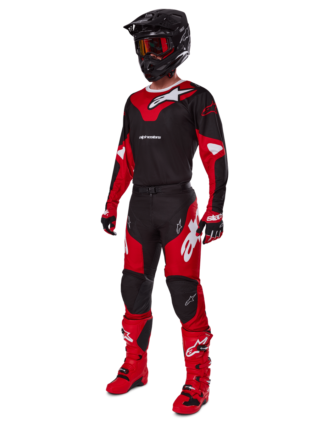 Piloto de motocross con equipamiento completo de competición que incluye el jersey Alpinestars 2025 Racer Veil en negro y rojo brillante, pantalones a juego, botas rojas, casco negro con gafas rojas y guantes rojos y negros, look coordinado de alto rendimiento para carreras off-road