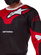 Alpinestars Racer Veil Jersey 2025, jersey de motocross, negro y rojo brillante, primer plano con un gran logotipo de Astars en blanco sobre un panel rojo en el pecho, texto de la marca en blanco y tejido técnico que absorbe la humedad