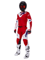 Alpinestars 2025 Racer Veil Gear Set, equipo de carreras de motocross, rojo brillante y blanco con detalles del logo en azul, usado con casco negro, guantes rojos y botas blancas, conjunto protector completo para rendimiento todoterreno