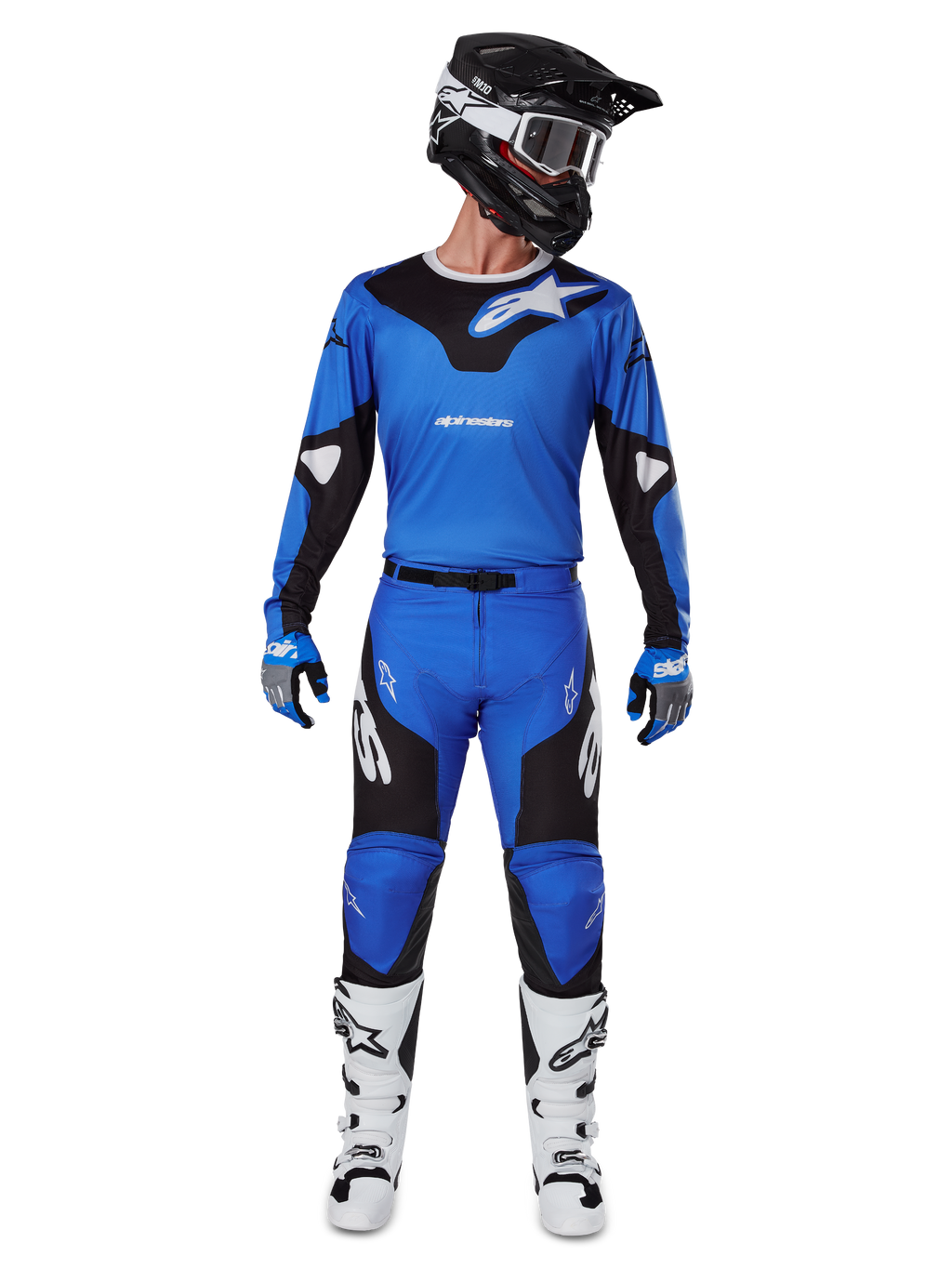 Piloto de motocross con el conjunto de equipo Alpinestars 2025 Racer Veil, jersey azul y negro con pantalones a juego, casco negro con gafas blancas, botas blancas y negras, atuendo de carreras coordinado para motocross off-road.