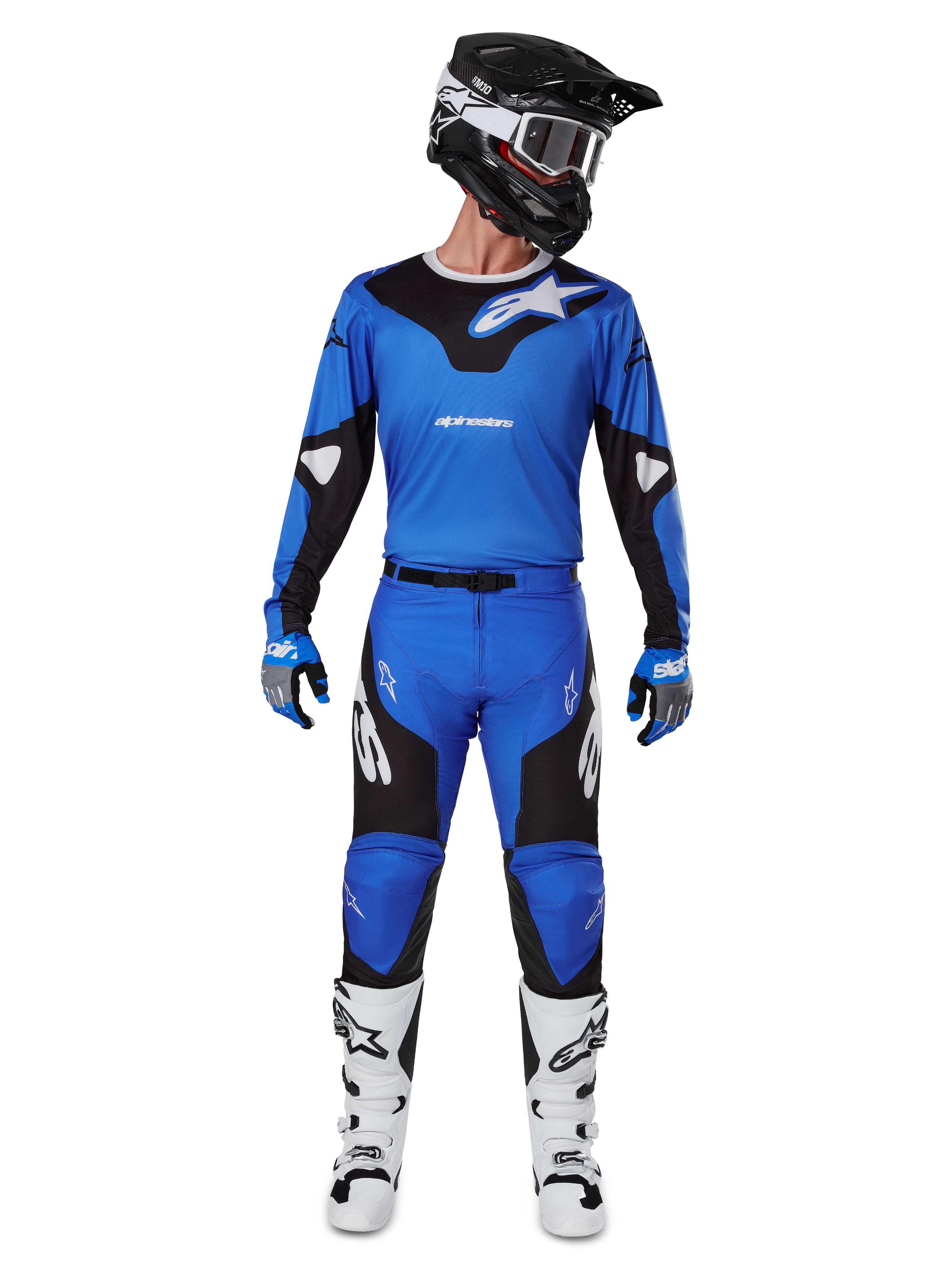 Piloto de motocross con el conjunto de equipo Alpinestars 2025 Racer Veil, jersey azul y negro con pantalones a juego, casco negro con gafas blancas, botas blancas y negras, atuendo de carreras coordinado para motocross off-road.