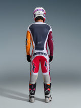 Motocross rider from behind wearing complete racing gear, 2026 Racer Portl Jersey in Red Light Gray and Dark Green with asymmetrical orange and maroon sleeves, matching white and red pants, white helmet with purple goggles, white and black boots, coordinated outfit for off-road racing
