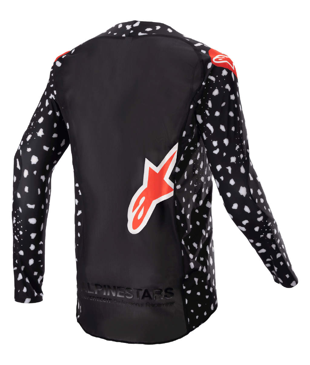 Alpinestars 2023 Supertech North Jersey, jersey de motocross, negro con patrón moteado blanco y detalles en rojo neón, vista trasera con logotipo grande de Alpinestars en rojo y marca en la parte inferior, equipamiento de carreras todoterreno de nivel profesional.