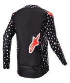 Alpinestars 2023 Supertech North Jersey, jersey de motocross, negro con patrón moteado blanco y detalles en rojo neón, vista trasera con logotipo grande de Alpinestars en rojo y marca en la parte inferior, equipamiento de carreras todoterreno de nivel profesional.