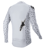Alpinestars 2023 Supertech North Jersey, jersey de motocross, gris Haze y negro, vista trasera con un patrón de manchas abstractas en las mangas y los laterales, logotipo de estrella grande, panel trasero extendido y construcción de rendimiento transpirable
