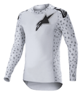Alpinestars 2023 Supertech North Jersey, camiseta de motocross, gris Haze y negro, camiseta de manga larga blanca con patrón de manchas grises en las mangas y los laterales, logotipo de estrella negro en el pecho y los hombros, malla elástica de alto rendimiento con dobladillo curvo