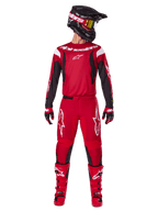 Conjunto de equipo Alpinestars 2025 Fluid Haul, traje de carreras de motocross en rojo brillante y negro, con jersey rojo de mangas negras y logotipos blancos, pantalones rojos a juego con logos de estrellas blancas, casco negro con gafas de lente dorada y botas rojas, equipamiento completo para conducción off-road