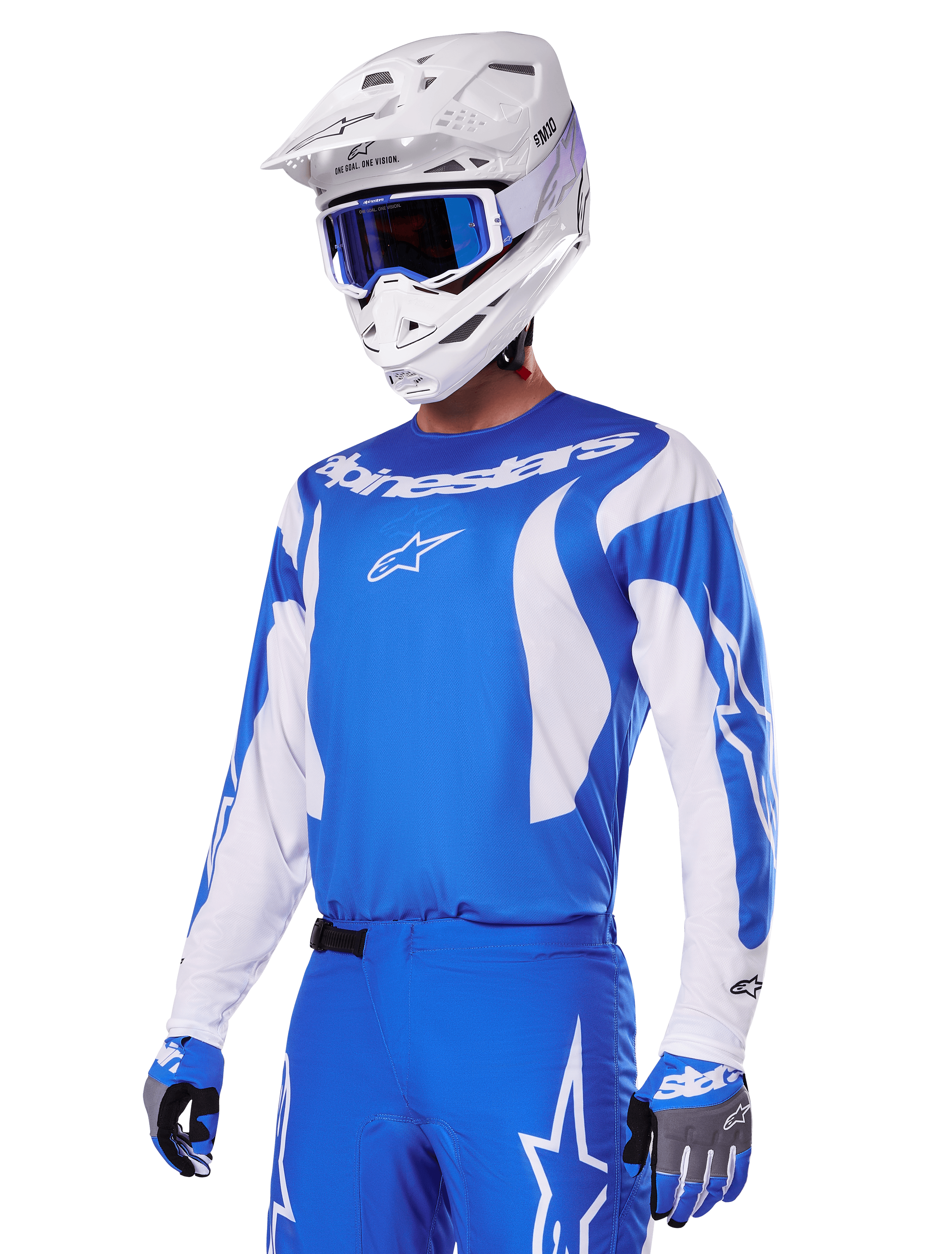 Motocross rider wearing the Alpinestars 2025 Fluid Haul Gear Set in Blue and White, featuring a blue jersey with white accents, matching blue pants with star logos, a white helmet with blue goggles, and coordinated blue and grey gloves, complete off-road racing outfit.