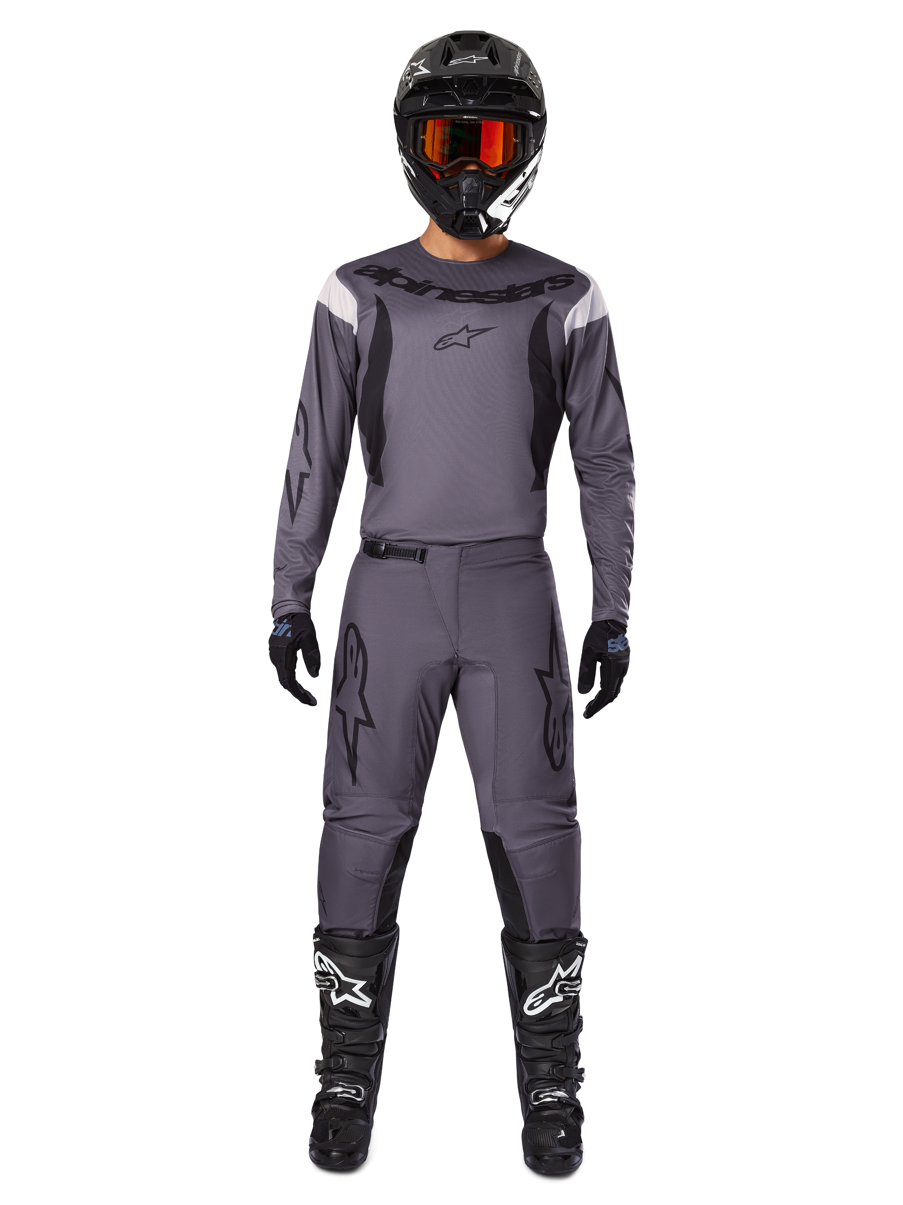 Alpinestars 2025 Fluid Haul Gear Set, equipo de motocross, gris, jersey y pantalones grises con detalles en negro, casco negro con gafas naranjas, botas negras con logotipos blancos, conjunto de carreras coordinado para rendimiento off-road