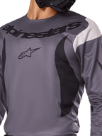 Alpinestars Fluid Haul Jersey 2025, jersey de motocross, gris con detalles en negro y blanco, con el logotipo y el nombre de la marca Alpinestars en el pecho, ajuste deportivo para carreras off-road