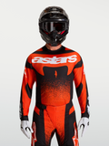 Alpinestars Techstar Swan Jersey, jersey de motocross para hombre, rojo cardinal y negro, ajuste de rendimiento mostrado en modelo con casco y guantes