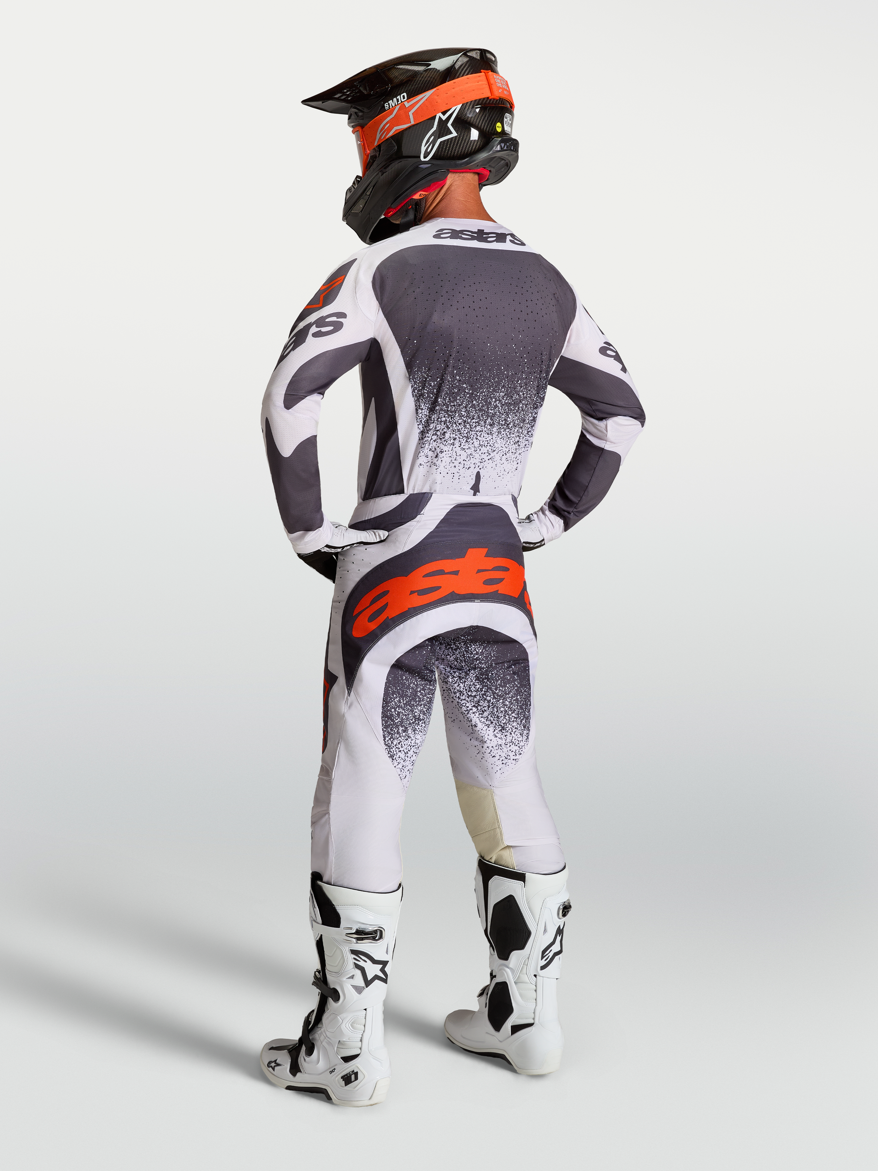 Alpinestars jersey Techstar Swan y gear set, conjunto de motocross para hombre en gris oscuro y rojo fluo.