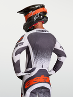 Jersey Techstar Swan, jersey de motocross para hombre, gris oscuro y blanco, con detalles rojos y logotipo Astars, ajuste de carrera atlético, visto desde atrás en piloto.
