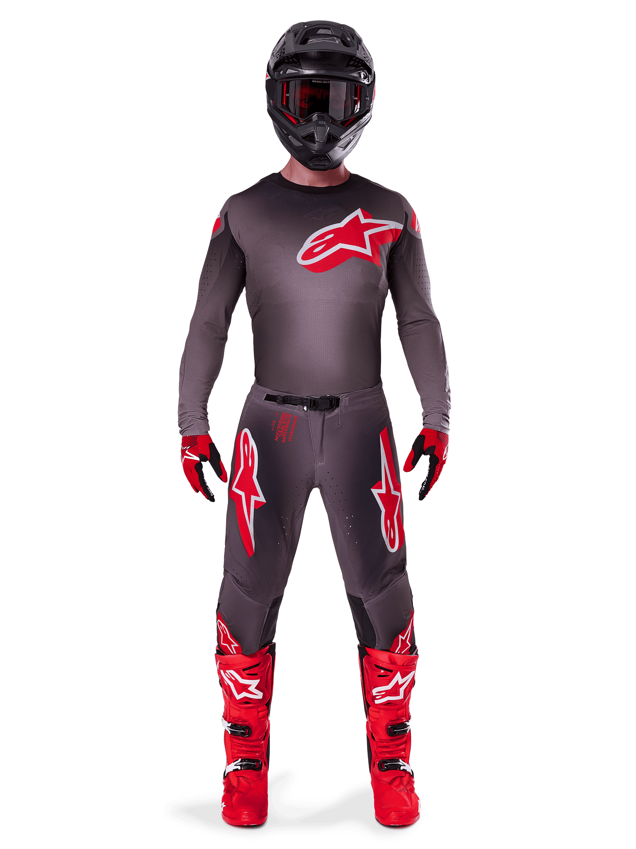 Motocross rider wearing complete racing gear, 2025 Supertech Lipan Jersey in Smoke Bright Red, matching grey pants with red logos, bright red boots, black helmet with goggles, and red and black gloves, professional motocross outfit.
