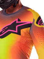 Primer plano del jersey Alpinestars Supertech Lipan 2025 en color amarillo y rosa, con un vibrante diseño degradado, un gran logotipo de estrella negra con borde rosa en el pecho y perforaciones cortadas con láser visibles para un mayor flujo de aire.