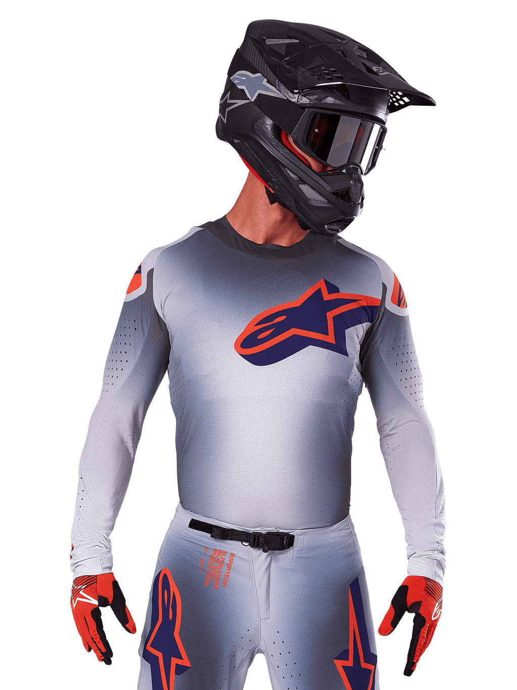 Alpinestars Supertech Lipan Jersey 2025, jersey de motocross de manga larga, gris con detalles en naranja y azul marino, camiseta técnica con perforaciones de ventilación, usado con casco negro y guantes rojos, diseño de competición estilizado